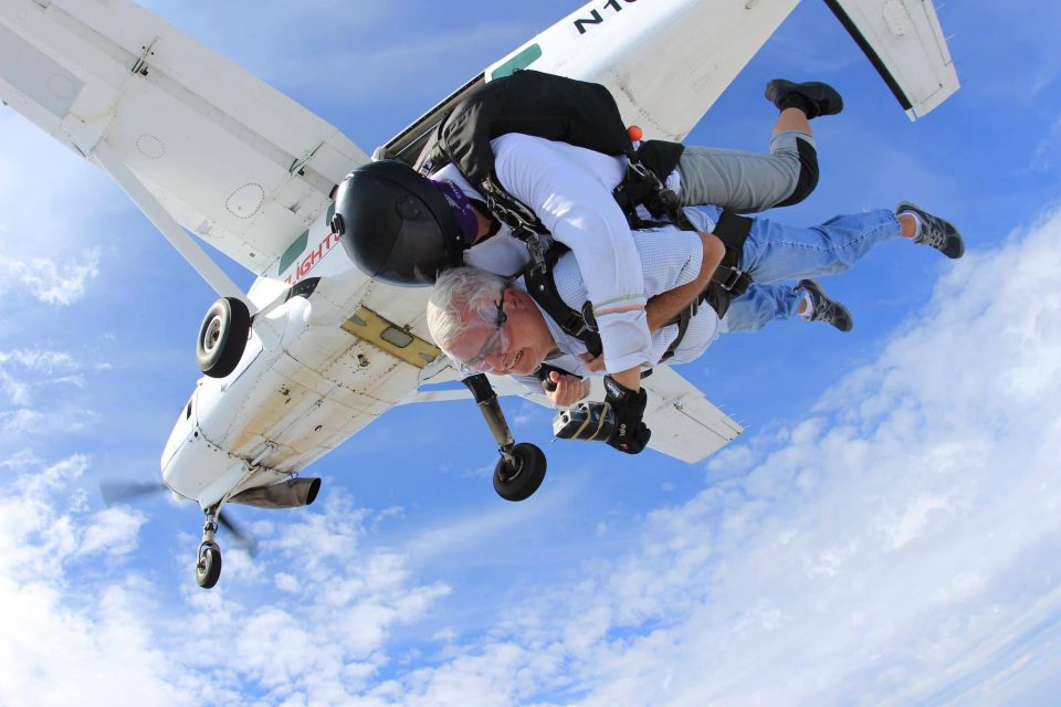 Older gentlemen enjoying the rush of free fall after leaping from the skydiving company aircraft