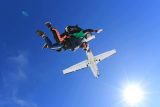 Male tandem skydiver enjoys the beautiful blue skies after leaping into free fall