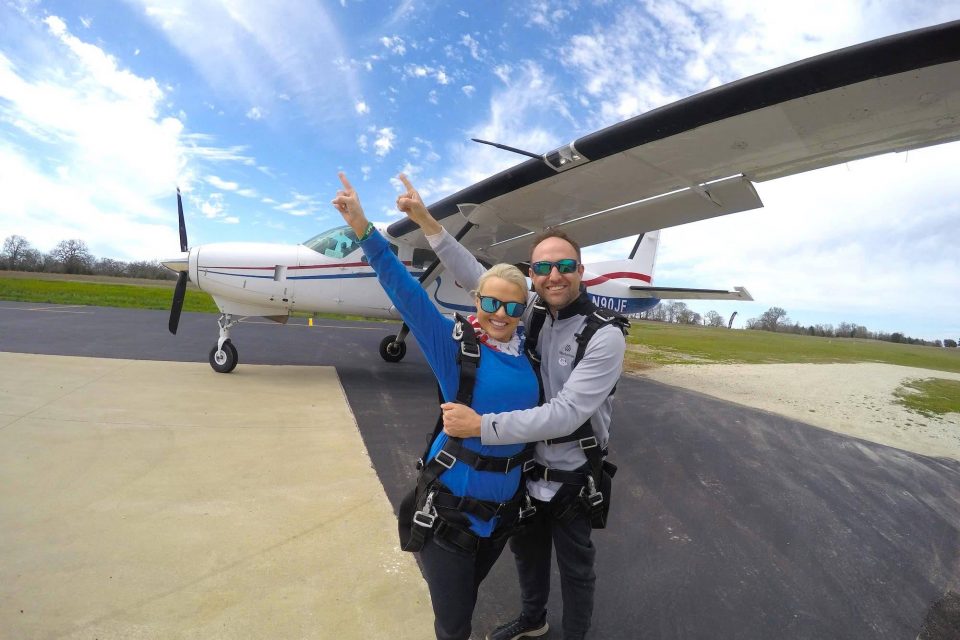 Two tandem jumpers hugging before going up in the skydiving company airplane for a skydive