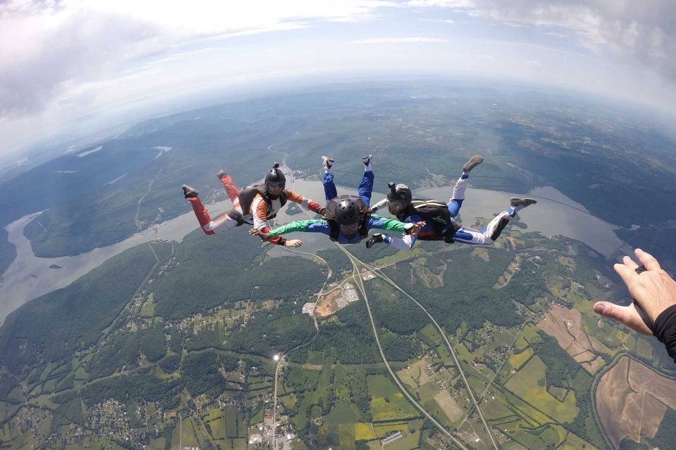 AFF student practices flying position during class with two instructors from the skydiving company in texas